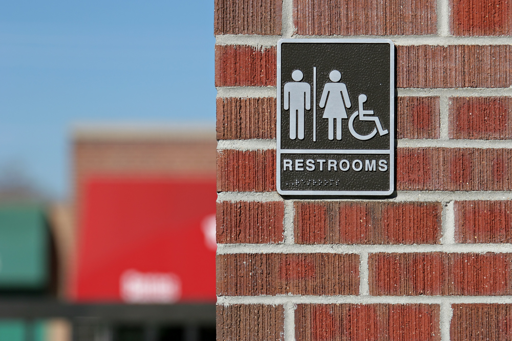 public restrooms sign, both genders and handicap accessible with wheelchair logo and braille